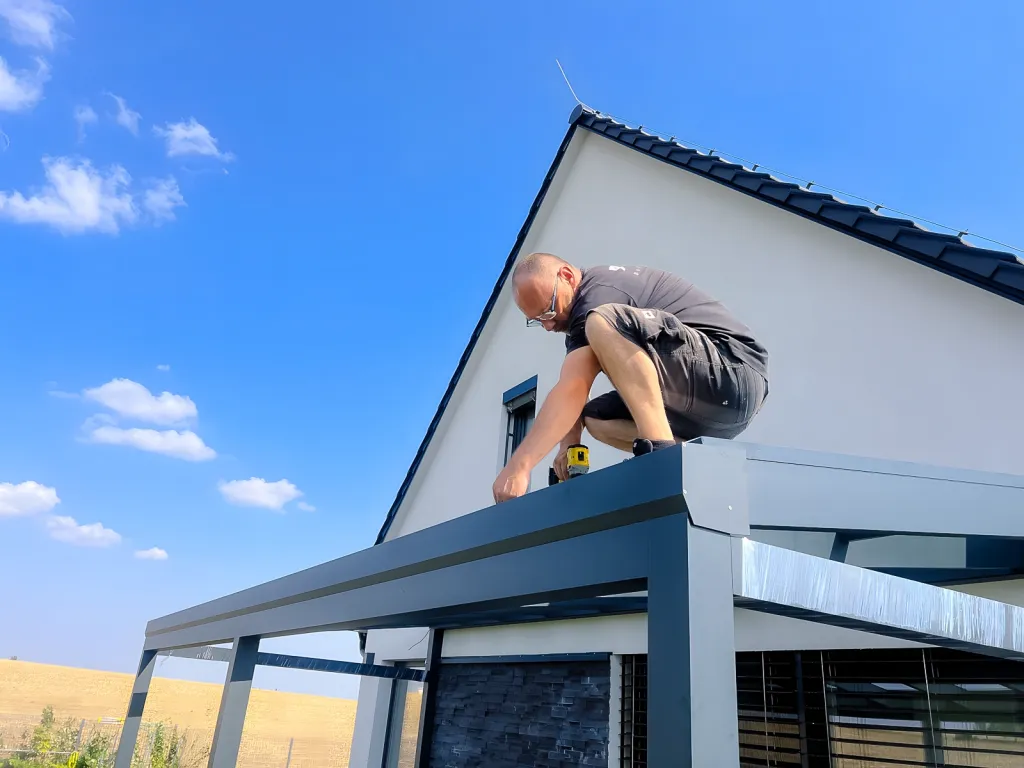 Pracovník PENEFu při montáži hliníkové pergoly