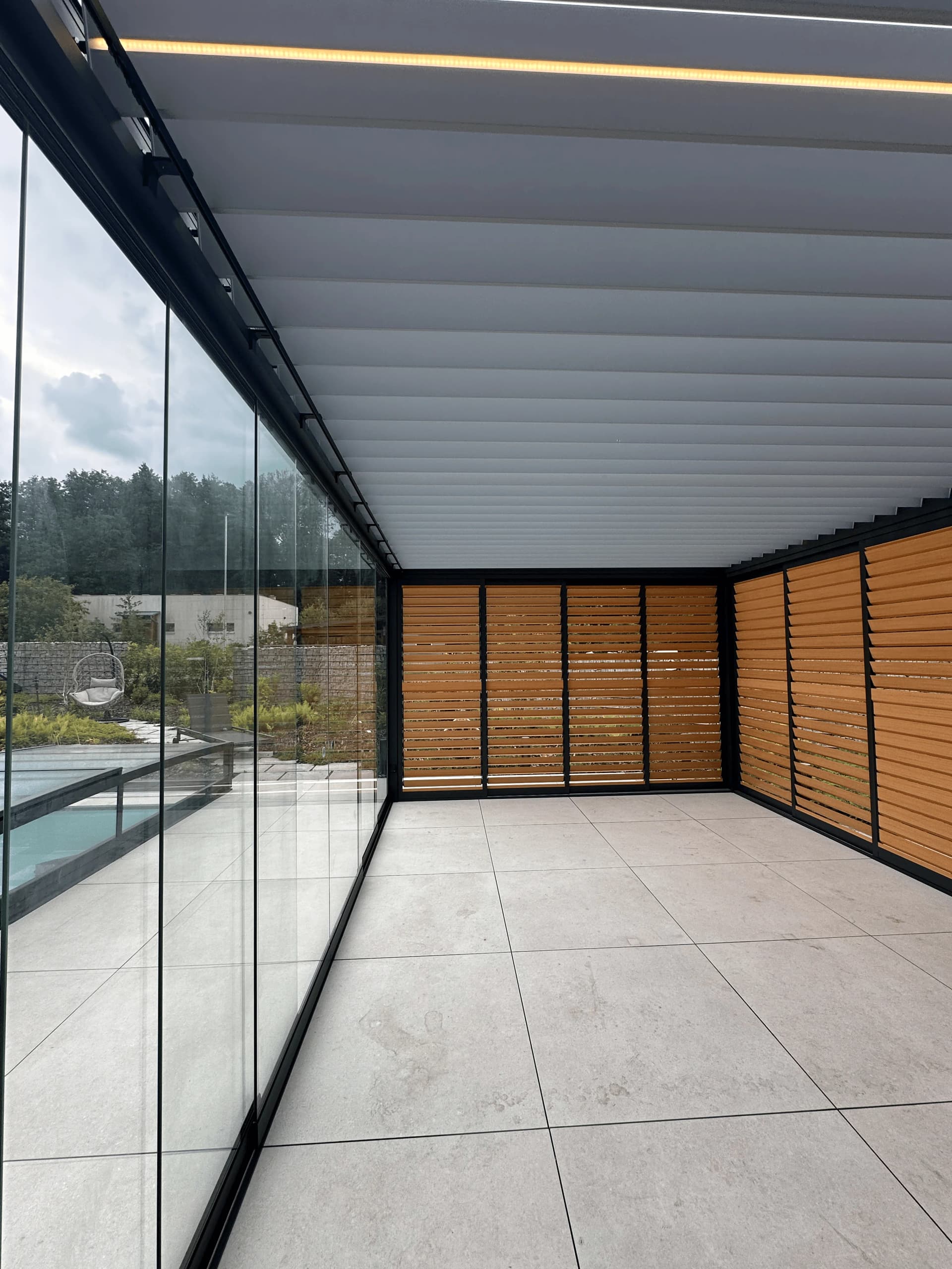Uzavřená bioklimatická pergola s posuvným sklem a slunolamy